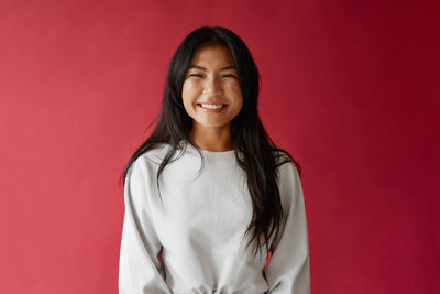 bright-smile-in-front-of-red-background - Simthread - High Quality Machine Embroidery Thread Supplier